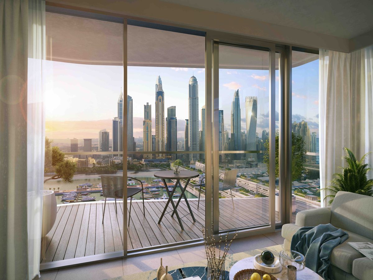 Emaar's render of a South Beach living room: floor-to-ceiling glass, a balcony with a bistro table and the Dubai Marina towers across the harbour
