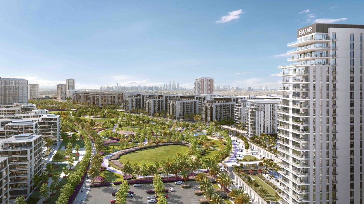 Emaar's render of a park district at Dubai Hills Estate from the air: an oval lawn among mid-rise apartment blocks and a tower on the right