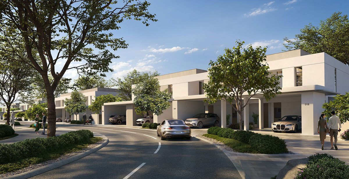 Emaar's render of a street at Kaia, The Valley: a row of two-storey townhouses with covered parking, young trees along the kerb and a car on the bend